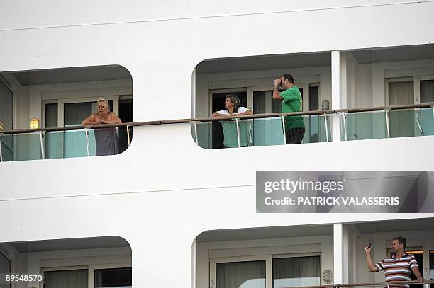 Passengers of the cruise boat 'Voyager of the seas' look out from the balconies of their cabins on August 1, 2009 at the harbour of Marseille,...