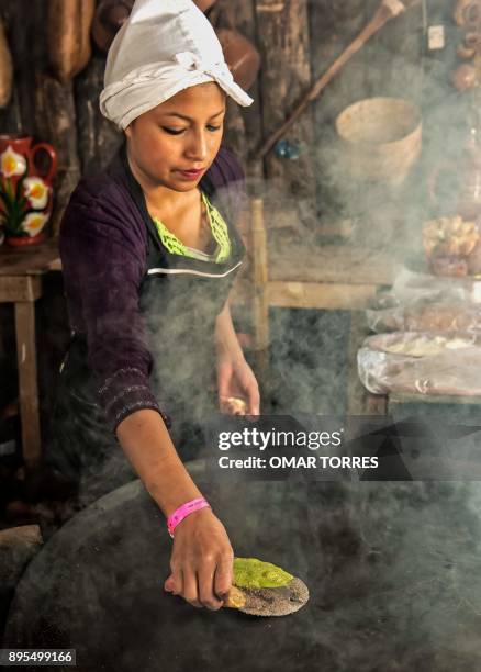 Dana Paola Alvarado makes a four-colour tortilla, made with red, white and blue corn and nopal , at a restaurant during the Mole Fair in San Pedro...