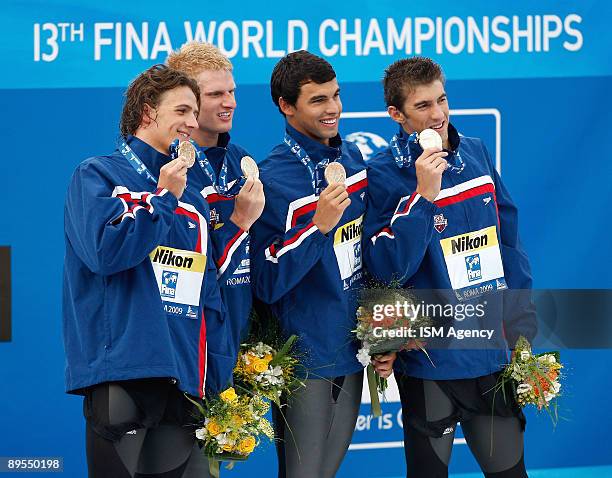 Michael Phelps of United States and the USA Team pose with the gold medal after the Men's 4x200m Freestyle Final, during the 13th FINA World...