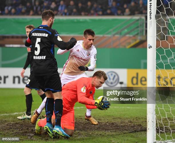 Michael Ratajczak of Paderborn makes a save from Stefan Lex of Ingolstadt during the DFB Cup match between SC Paderborn and FC Ingolstadt at Benteler...