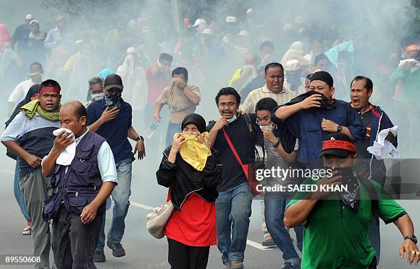 Demonstrators flee as Malaysian anti-riot police fire tear gas shells near Merdeka Square in Kuala Lumpur on August 1, 2009. Malaysian police fired...