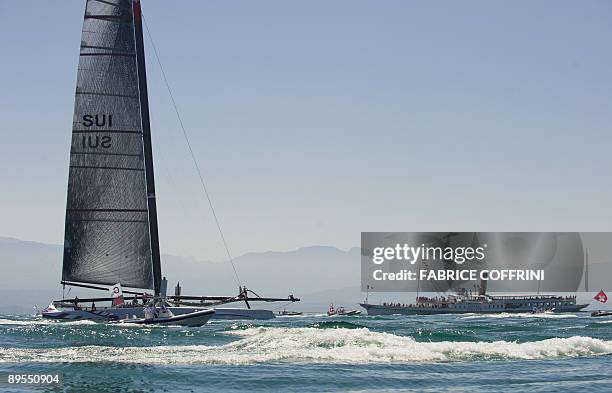 America's Cup defender Alinghi's new giant high tech catamaran "Alinghi 5" sails next to a commercial boat during its parade at Lake Geneva on the...