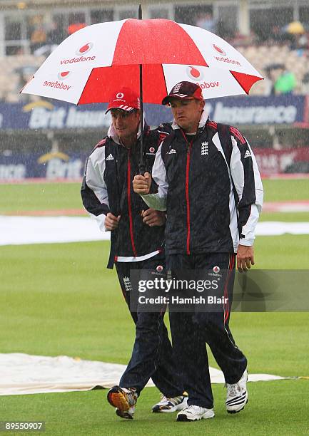 Andrew Strauss of England and coach Andy Flower walk across the pitch in heavy rain during day three of the npower 3rd Ashes Test Match between...