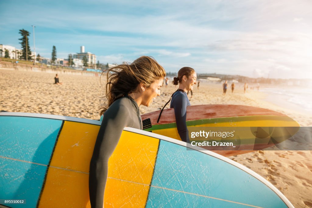 Female surfers rushing to catch a waves