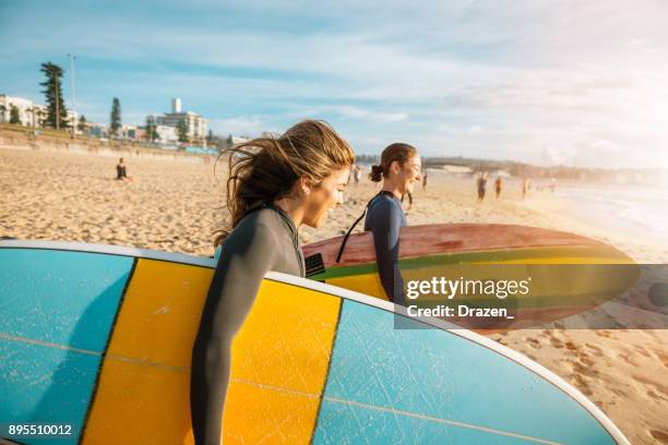 female surfers rushing to catch a waves - surfing australia stock pictures, royalty-free photos & images