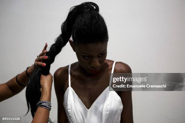 Contestant gets her hair braided in the backstage of the 3rd edition of Miss Africa Italy, on December 16, 2017 in Milan, Italy. Miss Africa Italy is...