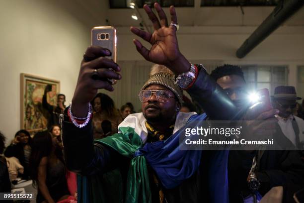 Man wearing a national flag of Sierra Leone takes a picture with his smartphone during the 3rd edition of Miss Africa Italy, on December 16, 2017 in...