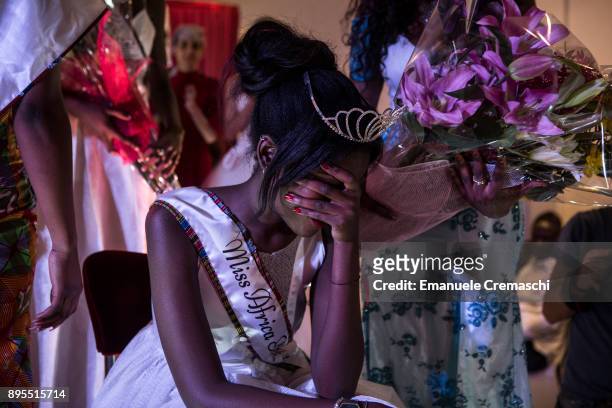 Merit, an 18 years old young girl of Nigerian origins, cries moments after having won the title of Miss Africa Italy, on December 16, 2017 in Milan,...