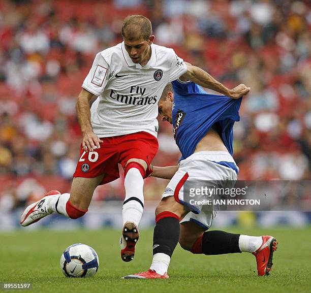 Christophe Jallet of Paris Saint-Germain is challenged by Aaron Niguez of Rangers during the Emirates Cup competition at The Emirates Stadium in...