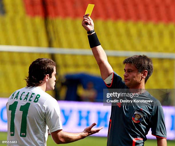 Referee Ildus Biglov shows a yellow card to Alan Kasaev of FC Kuban Krasnodar looks on during the Russian Football League Championship match between...