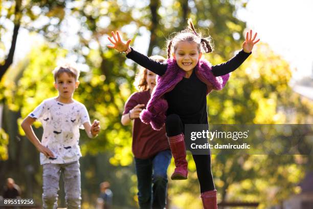 kinderen met plezier buiten - basisschoolgebouw stockfoto's en -beelden