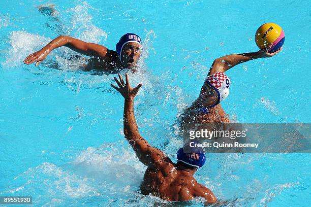 Sandro Sukno of Croatia makes a pass between Justin Johnson and Ryan Bailey of the United States in the Men's Water Polo Final Bronze Medal Match...