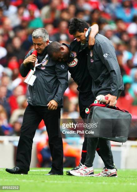 The injured Florent Sinama-Pongolle of Athletico is helped from the pitch during the Emirates Cup match between Arsenal and Athletico Madrid at the...