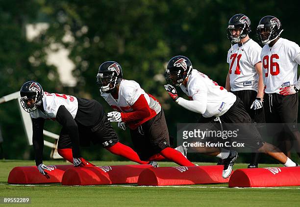 Defensive lineman John Abraham, Jonathan Babineaux and Jamaal Anderson of the Atlanta Falcons run drills during opening day of training camp on...