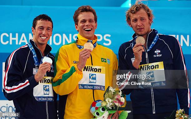 Frederick Bousquet of France celebrates the silver medal, Cesar Cielo Filho of Brazil the gold medal and Amaury Leveaux of France the bronze medal...