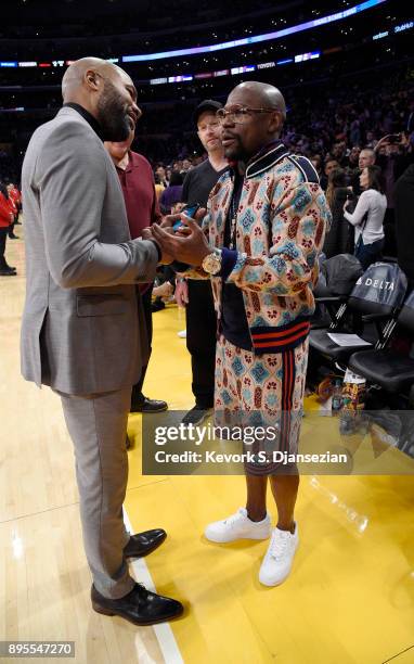 Floyd Joy Mayweather Jr., speaks with former Los Angeles Lakers player Derek Fisher as they attend a basketball game between the Golden State...