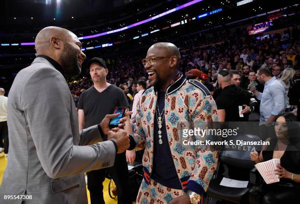 Floyd Joy Mayweather Jr., speaks with former Los Angeles Lakers player Derek Fisher as they attend a basketball game between the Golden State...