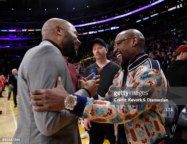 Floyd Joy Mayweather Jr., speaks with former Los Angeles Lakers player Derek Fisher as they attend a basketball game between the Golden State...