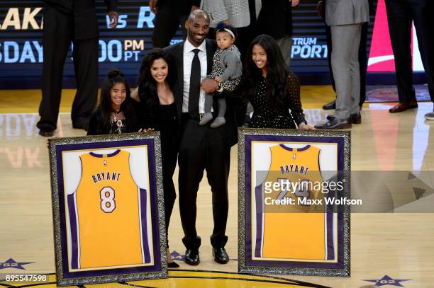 Kobe Bryant poses with his family at halftime after both his and Los Angeles Lakers jerseys are retired at Staples Center on December 18, 2017 in Los...