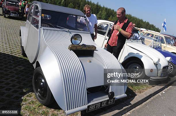 Two men look at a ''sci-fi'' tuning of a Citroen 2CV on August 1 during the 18th International meeting of Citroen 2CV car fans at the hippodrom in...