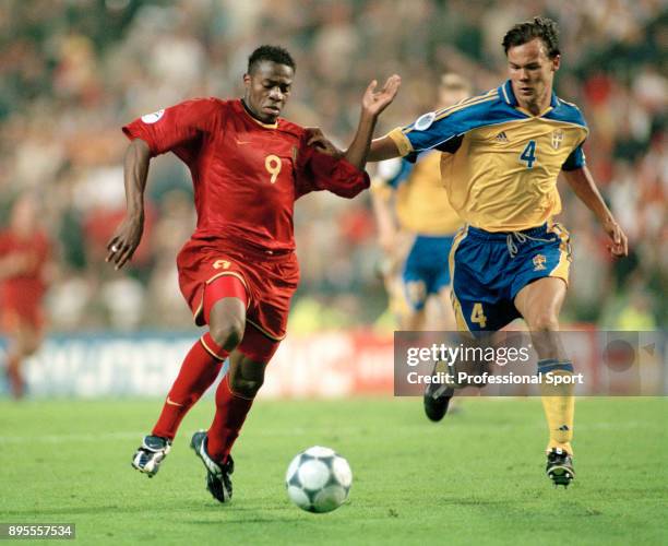Emile Mpenza of Belgium is tracked by Joachim Björklund of Sweden during a UEFA Euro 2000 group match at the King Baudouin Stadium on June 10, 2000...