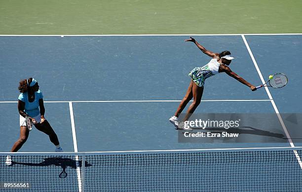 Venus Williams and Serena Williams of the USA return a shot during their doubles semi final match against Bethanie Mattek-Sands of the USA and Nadia...