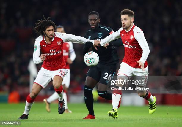 Arthur Masuaku of West Ham United is blocked by Mohamed Elneny and Mathieu Debuchy of Arsenal during the Carabao Cup Quarter-Final match between...