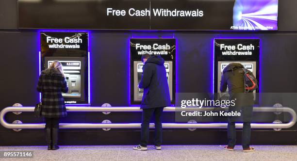 People withdraw cash from free ATM cash machines on December 16, 2017 in London, England.