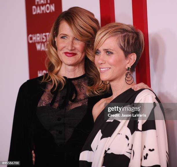 Actresses Laura Dern and Kristen Wiig attend the premiere of "Downsizing" at Regency Village Theatre on December 18, 2017 in Westwood, California.