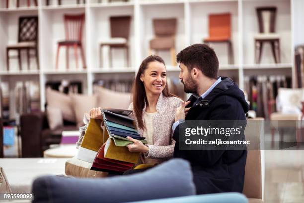 couple at a furniture store choosing fabrics - furniture stock pictures, royalty-free photos & images