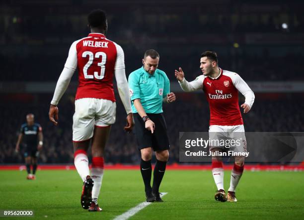 Referee Kevin Friend awards a free kick as Danny Welbeck and Sead Kolasinac of Arsenal appeal during the Carabao Cup Quarter-Final match between...