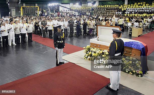 Family and supporters listen to mass during a wake for the late Philippine president Corazon Aquino as honour guards stand by her body at the La...