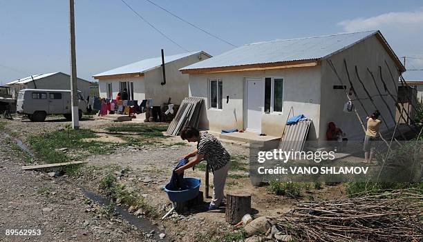 Picture taken on July 30, 2009 shows a woman washing her clothes outside her house in refugee settlement of Tserovani not far from Gori. Only 35...