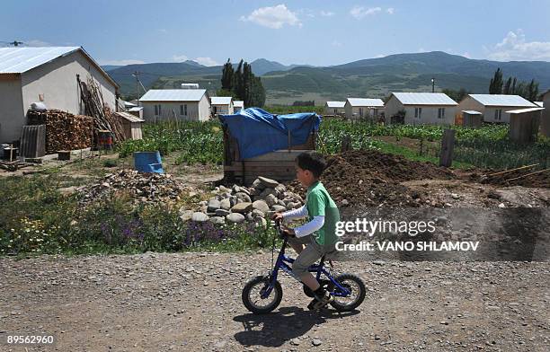 Picture taken on July 30, 2009 shows a Georgian boy rides bicycle in refugee settlement of Tserovani not far from Gori. Only 35 kilometres apart, the...