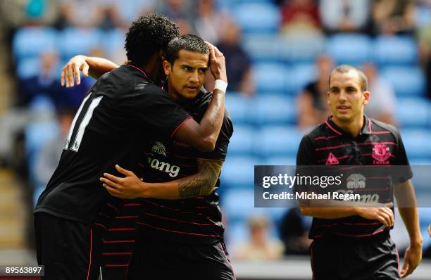 Tim Cahill of Everton is congratulated by team mate Jo and Leon Osman after scoring the opening goal during the pre season friendly match between...