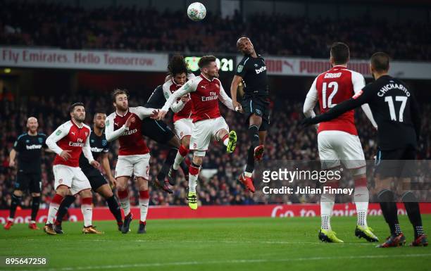 Andre Ayew of West Ham heads above Mathieu Debuchy of Arsenal during the Carabao Cup Quarter Finals match between Arsenal and West Ham United at...