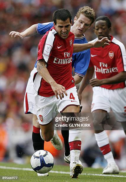 Arsenal's Spanish midfielder Cesc Fabregas goes past Rangers' Northern Irish midfielder Steven Davis during the Emirates Cup competition at the...