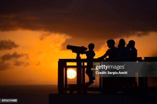 a child looking through a set of binoculars at sunset at two lovers point (puntan dos amantes), guam - panamint range stock pictures, royalty-free photos & images