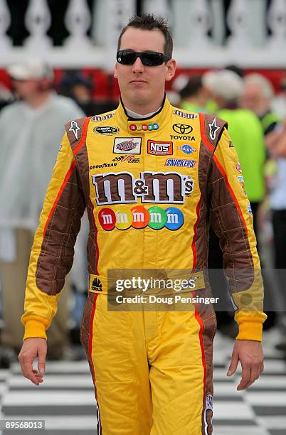 Kyle Busch, driver of the M&Ms Toyota, walks through pit road prior to the NASCAR Sprint Cup Series Sunoco Red Cross Pennsylvania 500 at the Pocono...