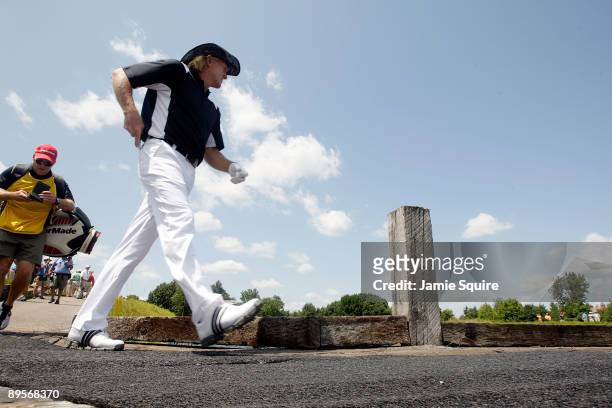 Greg Norman of Australia walks across a bridge to the teebox on the 4th hole during the final round of the 2009 U.S. Senior Open on August 2, 2009 at...