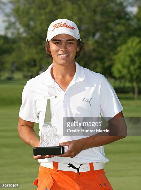 Rickie Fowler is awarded a smaller replica of the winner's trophy in honor of finishing as the low amateur in the field at the conclusion of the...