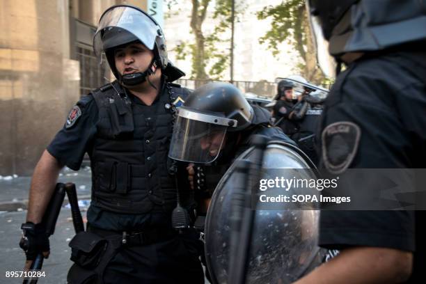 Police officer helps a wounded colleague to safety. Protestors from various left-wing groups attacked police after a largely peaceful demonstration...