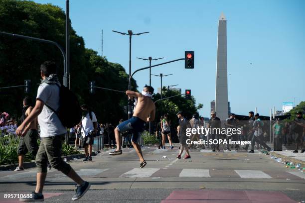 Protestor hurls a large rock at police on Avenida 9 de Julio. Protestors from various left-wing groups attacked police after a largely peaceful...