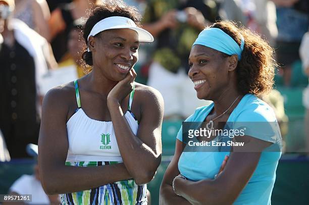 Serena Williams and Venus Williams smile as they converse before the trophy ceremony after winning the doubles final over Yung-Jan Chan of Taipei and...