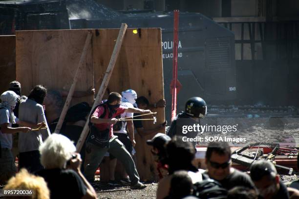 Demonstrators fire chunks of pavement from homemade slingshots. Protestors from various left-wing groups attacked police after a largely peaceful...