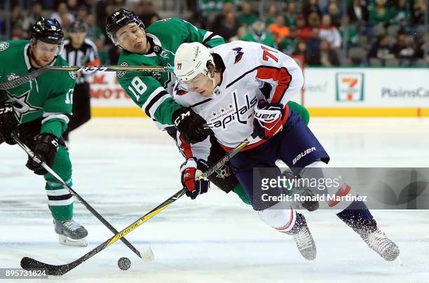 Oshie of the Washington Capitals skates the puck against Tyler Pitlick of the Dallas Stars in the first period at American Airlines Center on...