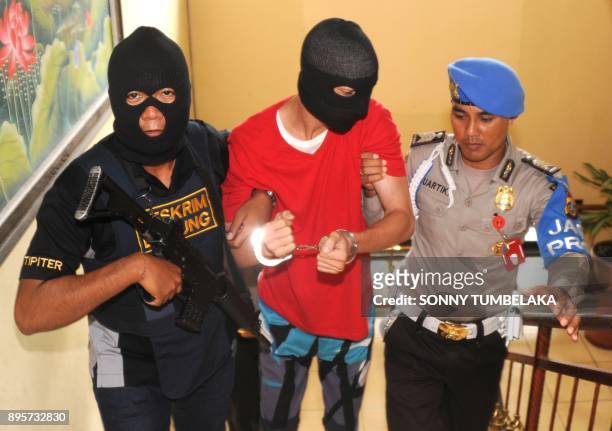 Indonesian police escort US prisoner Christian Beasley to a press conference at a police station in Badung regency, on Indonesia's resort island of...
