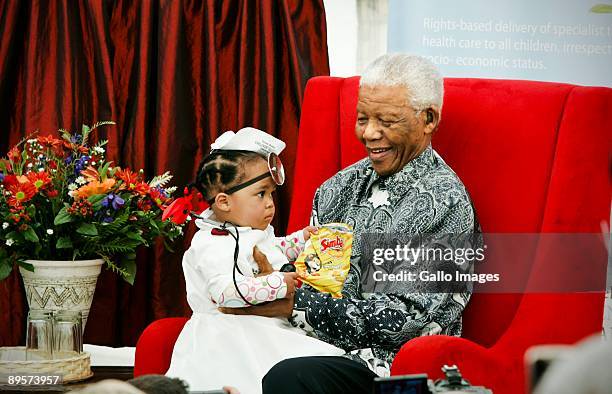 Michai'ah Simons, dressed as a doctor, sits with former South African president Nelson Mandela at the Nelson Mandela childrens fund annual...