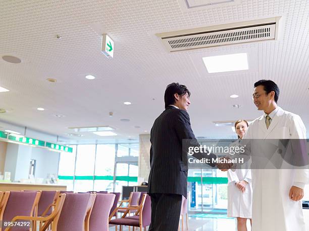 the man is shaking hands with the doctor.  - michael virtue stock pictures, royalty-free photos & images