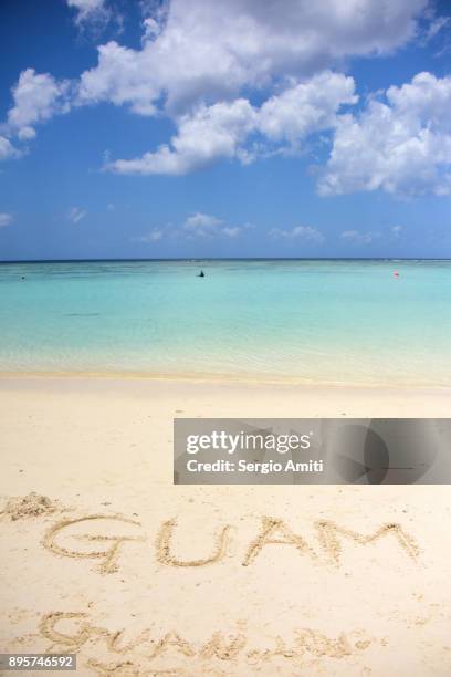 "guam" written in the sand - guam stock-fotos und bilder